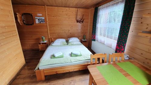 a bedroom with a bed in a wooden cabin at Przybyłówka in Szczyrk
