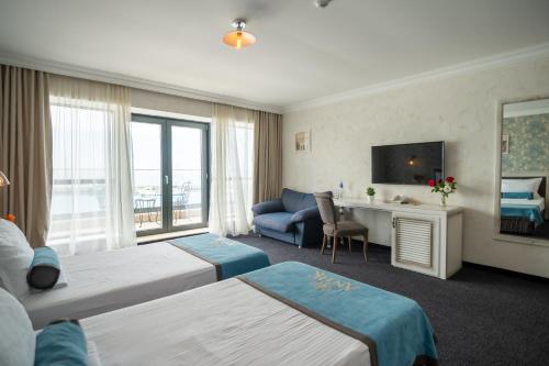 una camera d'albergo con 2 letti e una scrivania di Hotel Antik a Balchik