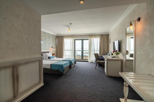 a hotel room with two beds and a desk at Hotel Antik in Balchik