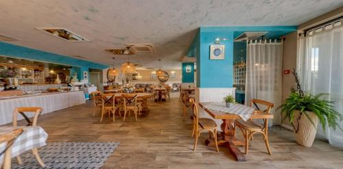 un ristorante con tavoli e sedie in legno e pareti blu di Hotel Antik a Balchik