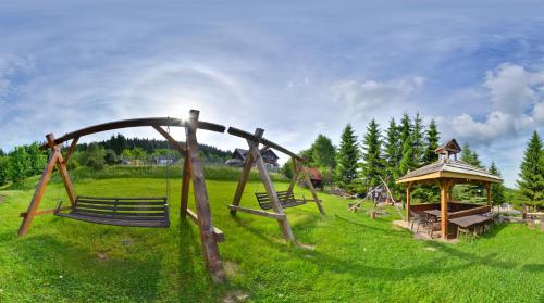 a park with two benches and a gazebo at Ośrodek Jagienka Zieleniec in Duszniki Zdrój