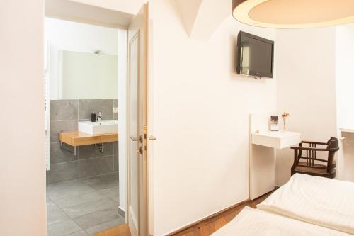 a bathroom with a bed and a sink and a mirror at restaurant271 in Burghausen