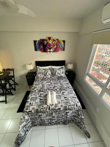a bedroom with a bed with a black and white bedspread at Studio completo e aconchegante in Ribeirão Preto