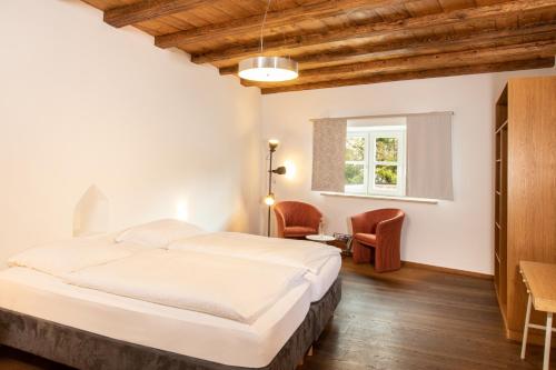a bedroom with a bed and a table and chairs at restaurant271 in Burghausen