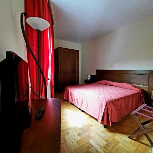 a bedroom with a bed and a red curtain at Hotel Bellavista in Abetone