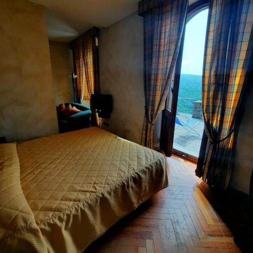 a bedroom with a bed and a large window at Hotel Bellavista in Abetone