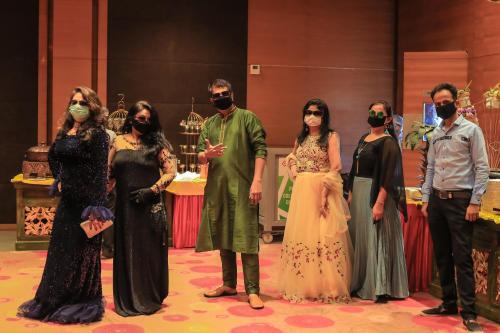 a group of people standing on a stage wearing masks at Hotel German Palace Near to Airport in Gandhinagar