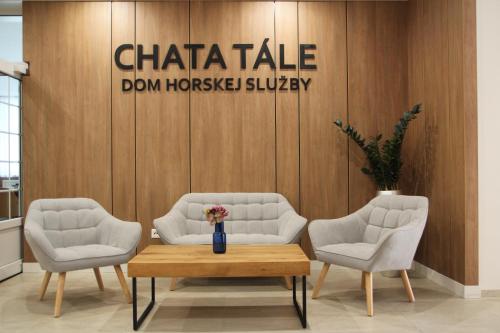een lobby met 2 stoelen en een tafel en een bord bij Chata Tale - Dom Horskej služby in Tale