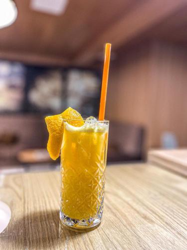 a glass of orange juice sitting on a table at Hotel Palcich Plitvice in Čatrnja