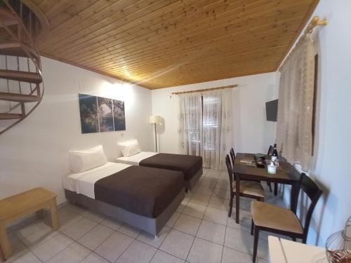 a bedroom with a bed and a desk and a bed and a chair at Marketos Apartments in Svoronata