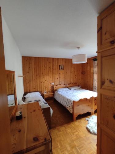 a bedroom with two beds and a desk in it at Ca' del bau in Chiesa in Valmalenco