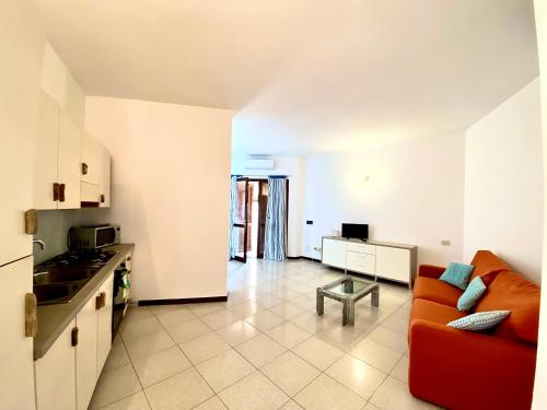 a kitchen and a living room with a red couch at Appartamento Fronte Mare in Santa Teresa Gallura