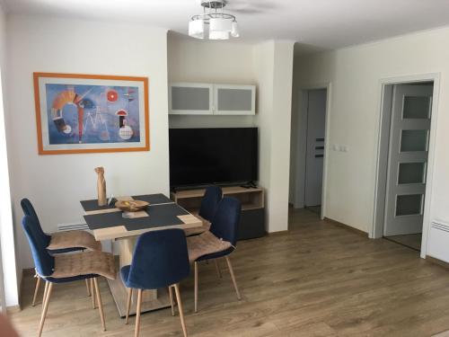 a dining room with a table and chairs and a television at ZÁMOR HOLIDAY HOUSE in Keszthely