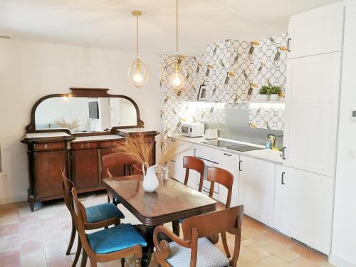 cocina con mesa, sillas y fregadero en Apartamentos Tres Llaves Palacio de Vela de los Cobos en Úbeda