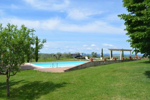 a swimming pool in a yard with a grass field at Casa Vacanze Il Fornacino in Asciano
