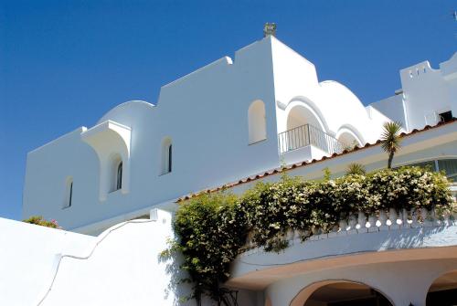 un edificio bianco con balcone fiorito di Hotel Terme Villa Teresa a Ischia