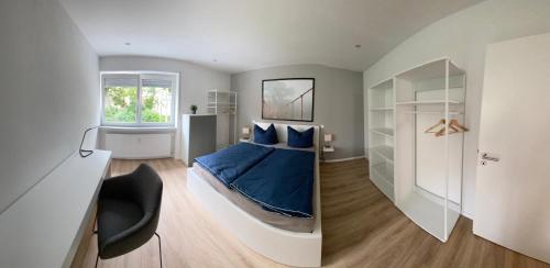 a bedroom with a bed with blue sheets and a window at Moderne Ferienwohnung Hergolshausen in Waigolshausen