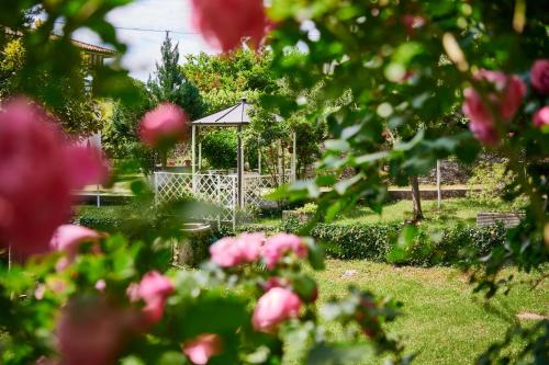 a gazebo in a park with pink flowers at Stazione 8 in Aurisina