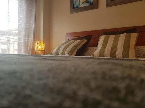 2 camas en un dormitorio con ventana en PLAYA DE SAN VICENTE DE LA BARQUERA, en San Vicente de la Barquera
