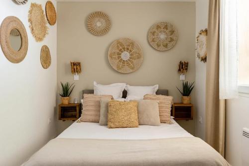 a bed in a bedroom with plates on the wall at Casa Tulum in Irigny