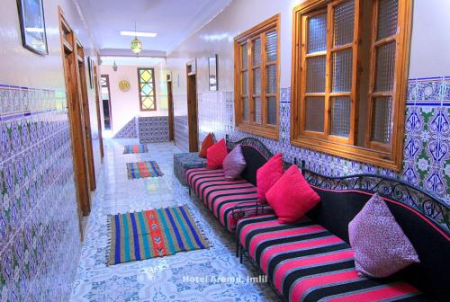 a room with a couch with colorful pillows at Hotel Igoudar Armed in Imlil