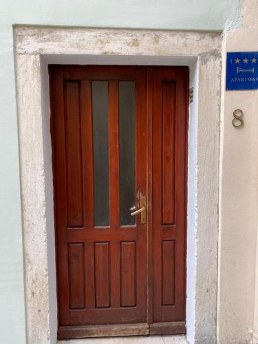- une porte en bois dans un bâtiment blanc dans l'établissement Apartment Zara, à Zadar