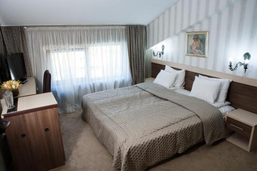 Un pat sau paturi într-o cameră la Spa Hotel Kleptuza