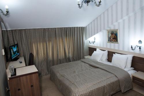 a hotel room with a bed and a television at Spa Hotel Kleptuza in Velingrad