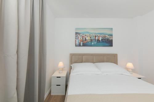 a bedroom with a bed and a painting on the wall at Enjoy Trogir Ciovo in Trogir