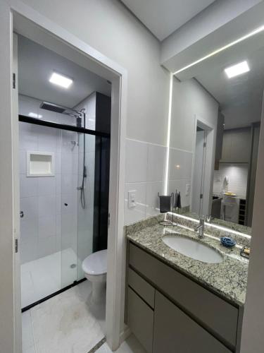 a bathroom with a sink and a toilet and a shower at Loft encantador e refinado in Ribeirão Preto