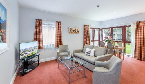 a living room with a couch and a tv at High Range Lodge Hotel in Aviemore