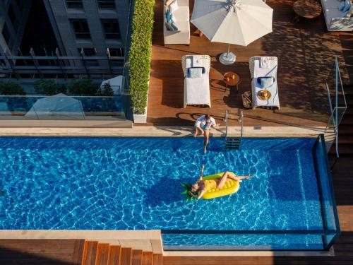 a couple of people are in a pool with a raft at Four Seasons Hotel Dubai International Financial Centre in Dubai