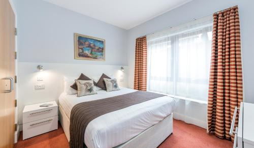 a bedroom with a large bed and a window at High Range Lodge Hotel in Aviemore