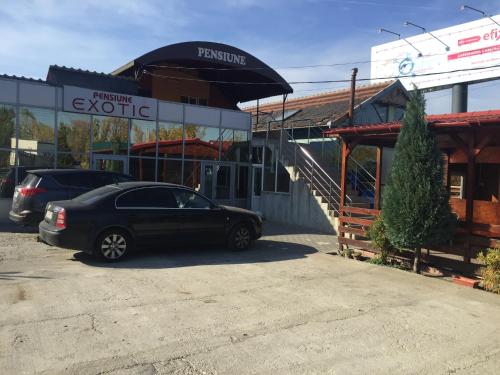 a car parked in a parking lot in front of a store at Pensiunea exotic in Craiova