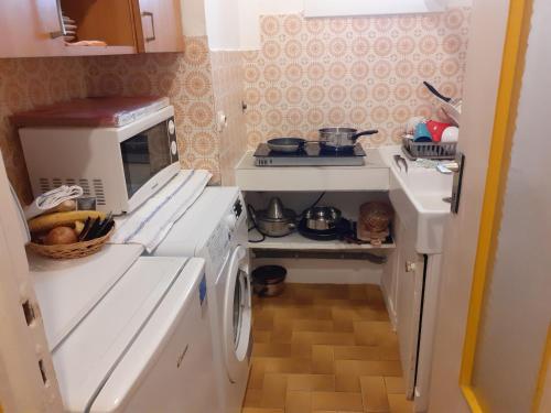 cocina pequeña con fogones y lavadora en Stella Apartment - Cannes, en Cannes
