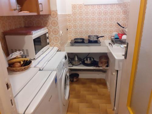 Il comprend une petite cuisine équipée d'une cuisinière et d'un lave-linge. dans l'établissement Stella Apartment - Cannes, à Cannes