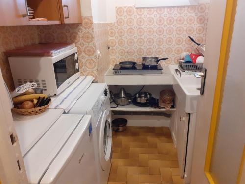 a small kitchen with a stove and a washing machine at Stella Apartment - Cannes in Cannes