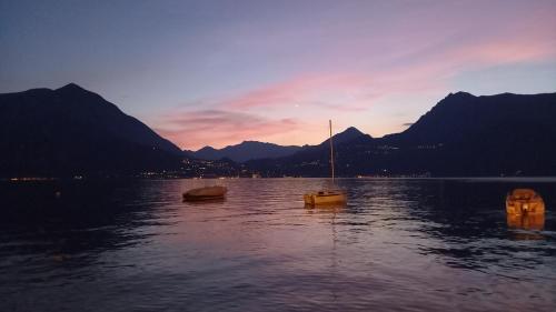 a couple of boats in the water at sunset at I Tre Oleandri Varenna in Varenna