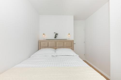 a white bedroom with a bed with white walls at Enjoy Trogir Ciovo in Trogir