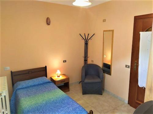 a bedroom with a bed and a chair and a lamp at Affittacamere Centro Storico in Raiano