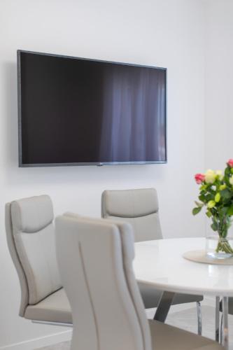 a meeting room with a table and chairs and a tv at Enjoy Trogir Ciovo in Trogir