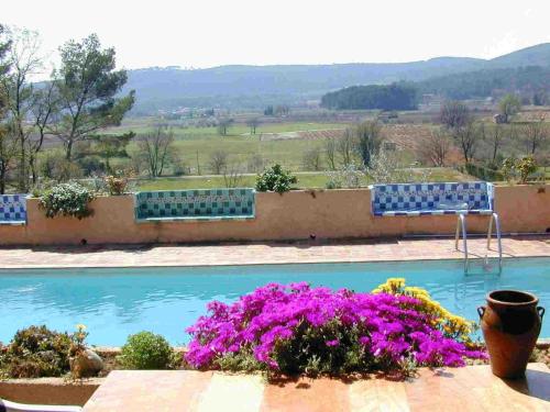 - une vue sur la piscine ornée de fleurs violettes dans l'établissement Villa Melocoton, à Figanières