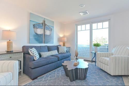 a living room with a blue couch and a table at Harbortown Suites in Plymouth