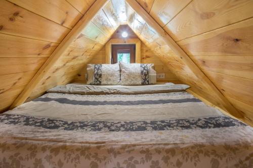 a bedroom in a log cabin with a large bed at Lux Bungalow in Žabljak