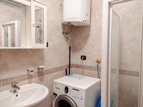 une salle de bains avec lave-linge et lavabo dans l'établissement Apartments Altea, à Rafailovici