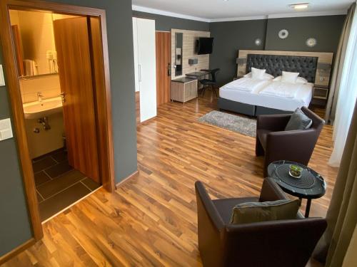 ZUM ZIEL Hotel Grenzach-Wyhlen bei Basel في غرنزاش ويلن: غرفة نوم مع سرير وغرفة معيشة