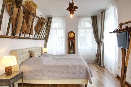 1 dormitorio con 1 cama y reloj en la pared en Ferienwohnung LANDHAUSSUITE Annaberg-Buchholz, en Annaberg-Buchholz