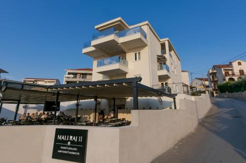 a building with a table and chairs in front of it at Enjoy Trogir Ciovo in Trogir