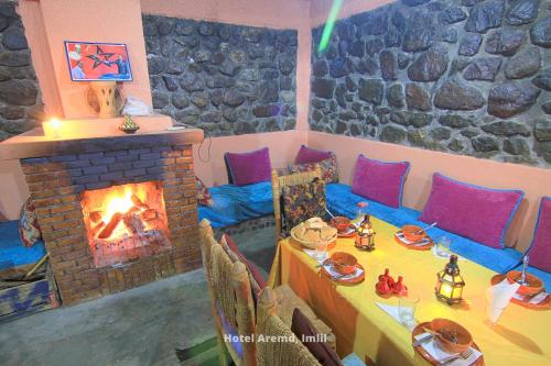 a living room with a fireplace and a table with food at Hotel Igoudar Armed in Imlil