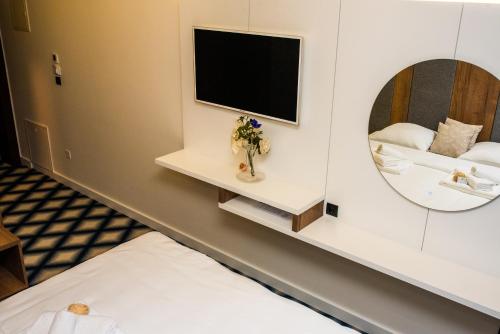 a room with a mirror and a bed and a sink at Swiss Plus Hotel in Bihać